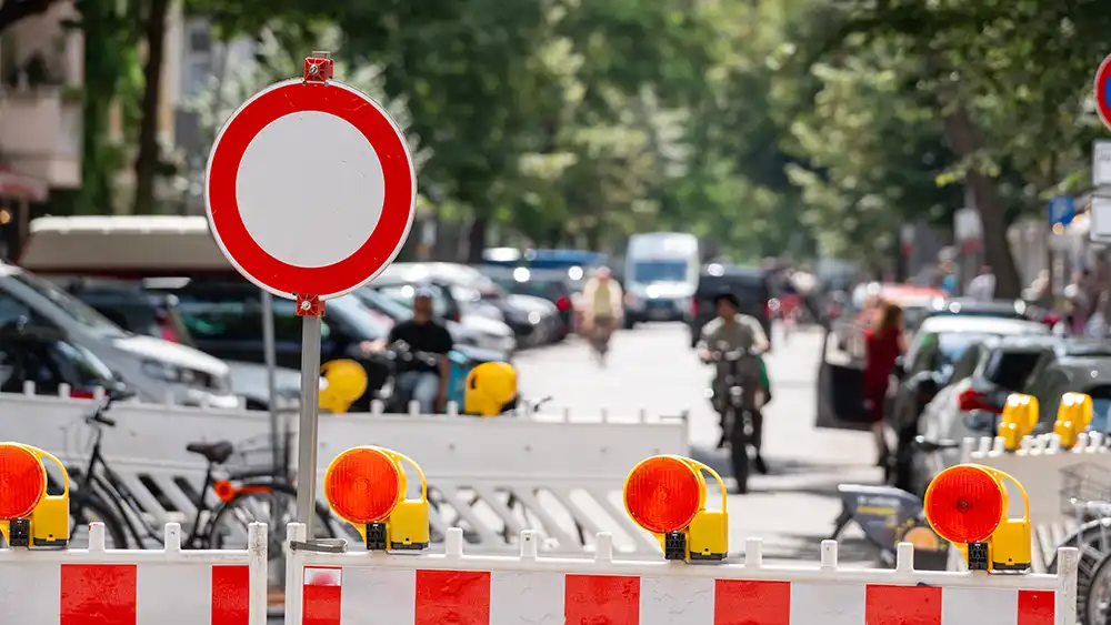 Parking lot blocked by construction barricades and signage.