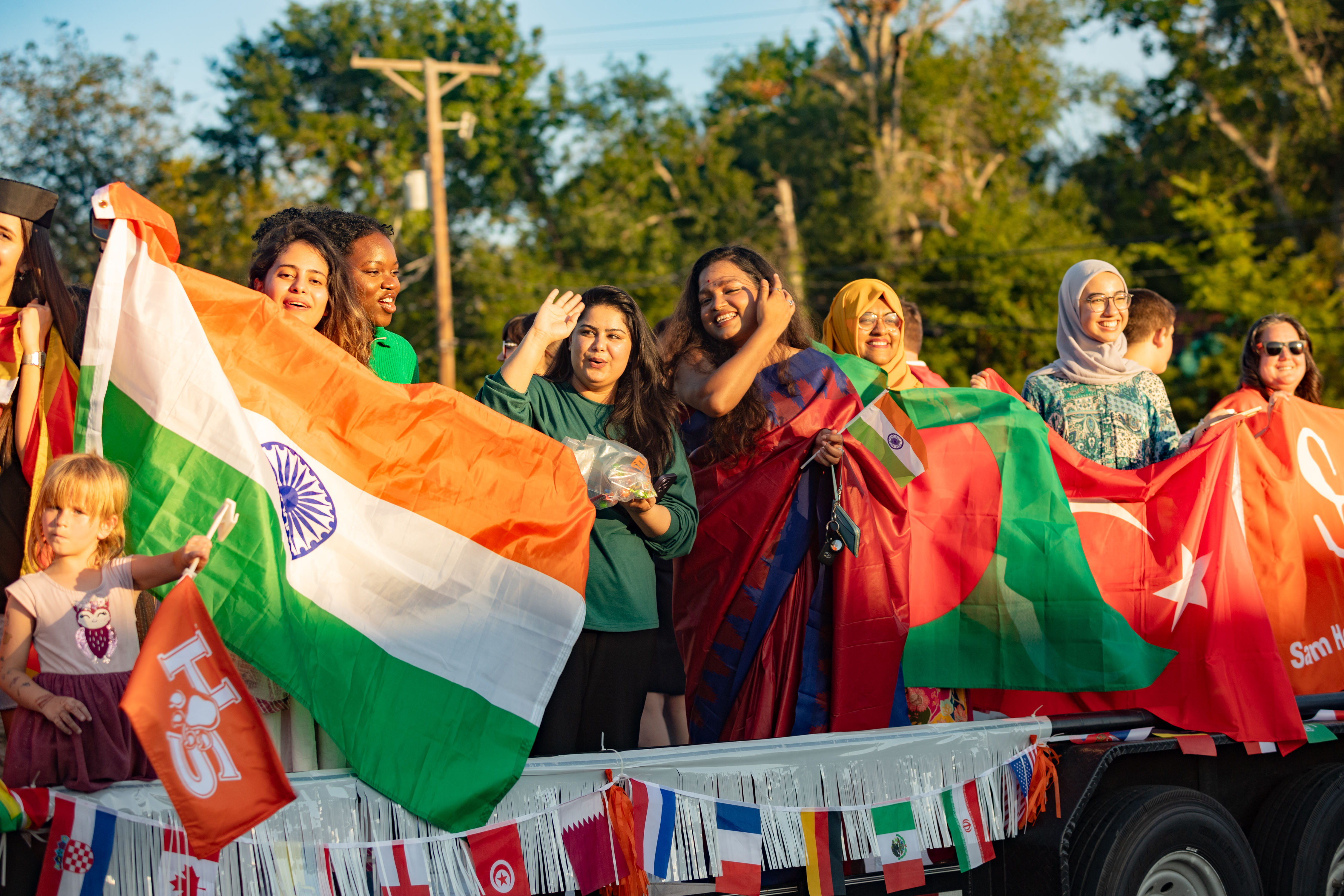 SHSU international students holding their flag during the Homecoming Parade.