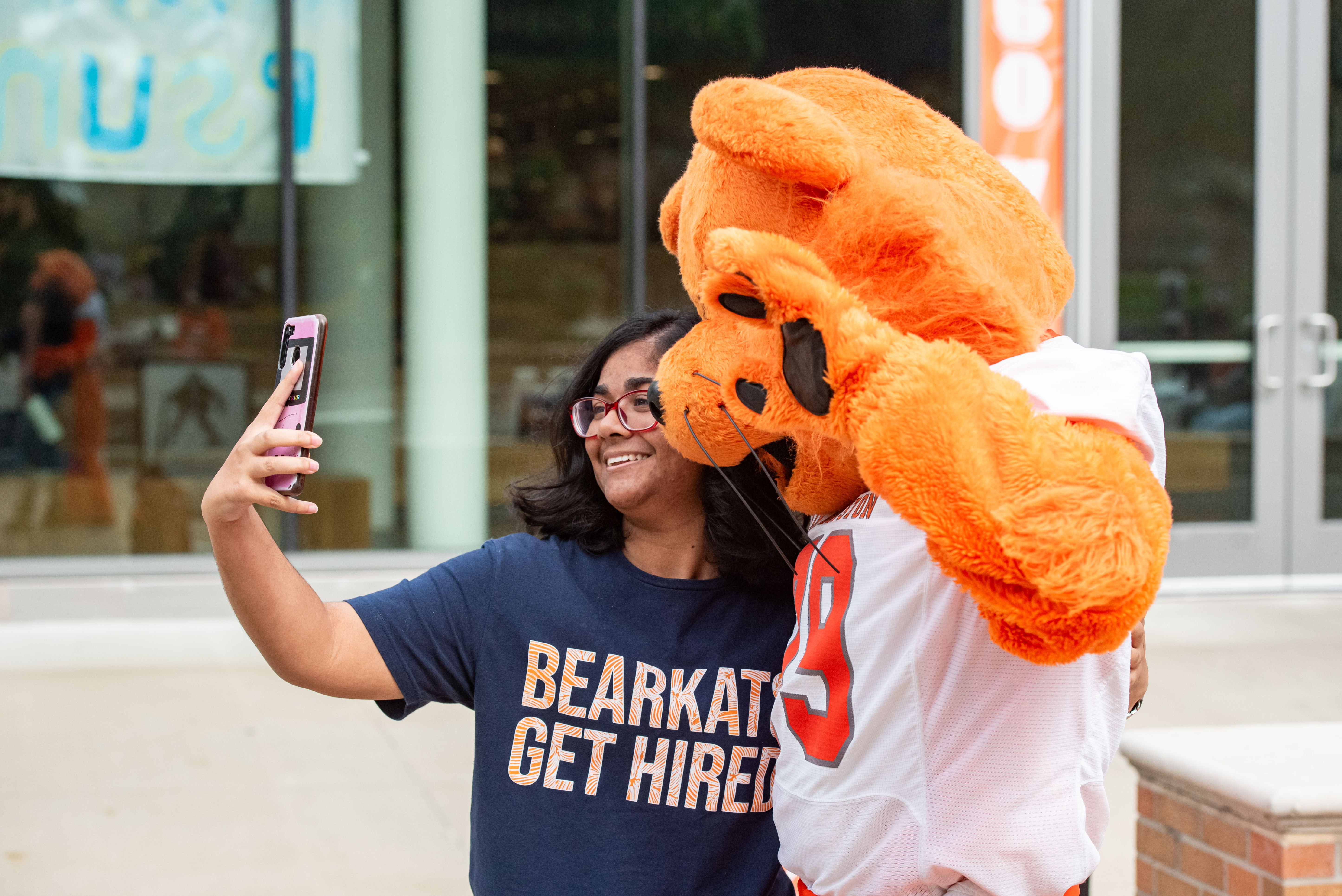 ​SHSU international student taking a selfie with Sammy the Bearkat.  