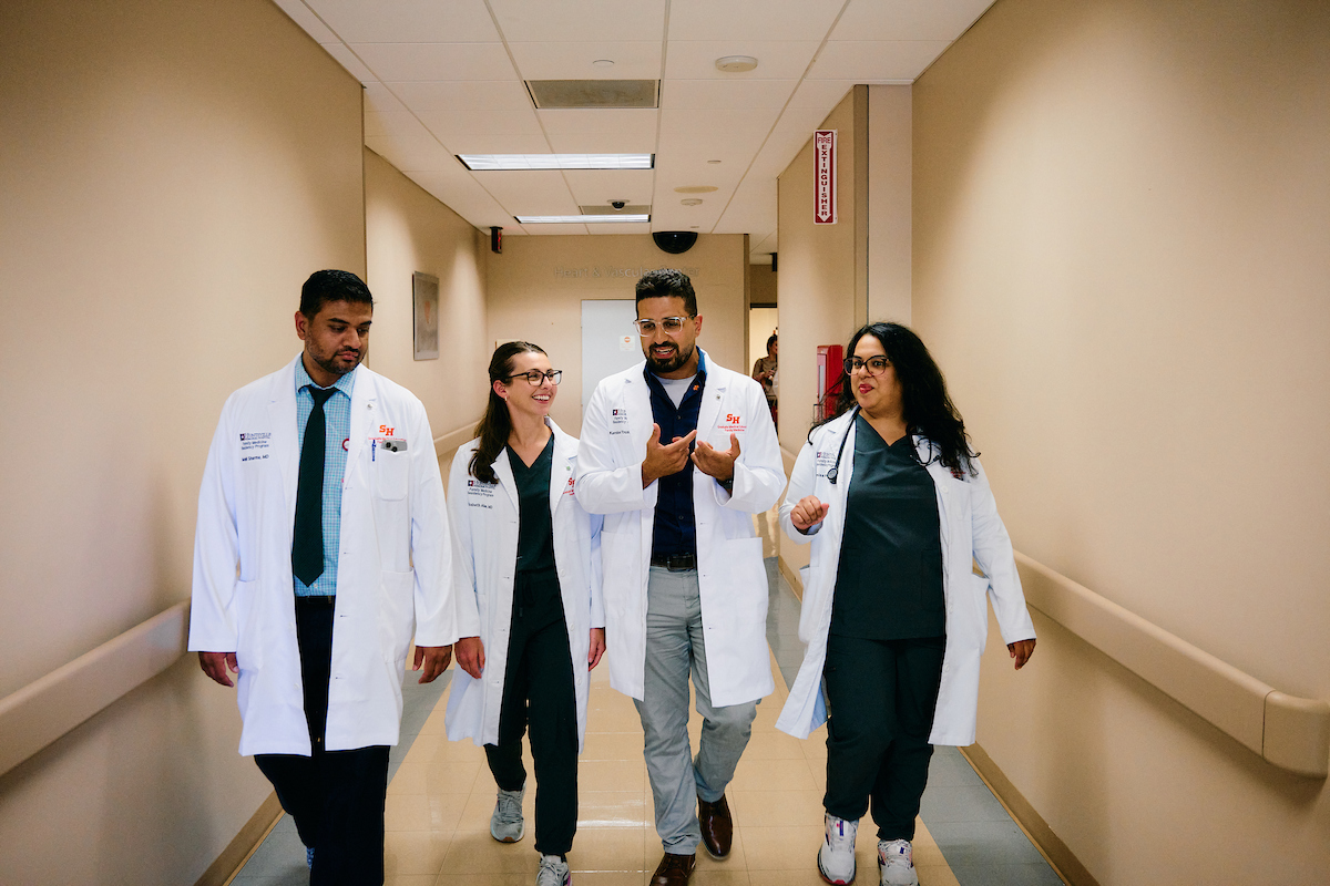 doctors talking and walking down a hallway