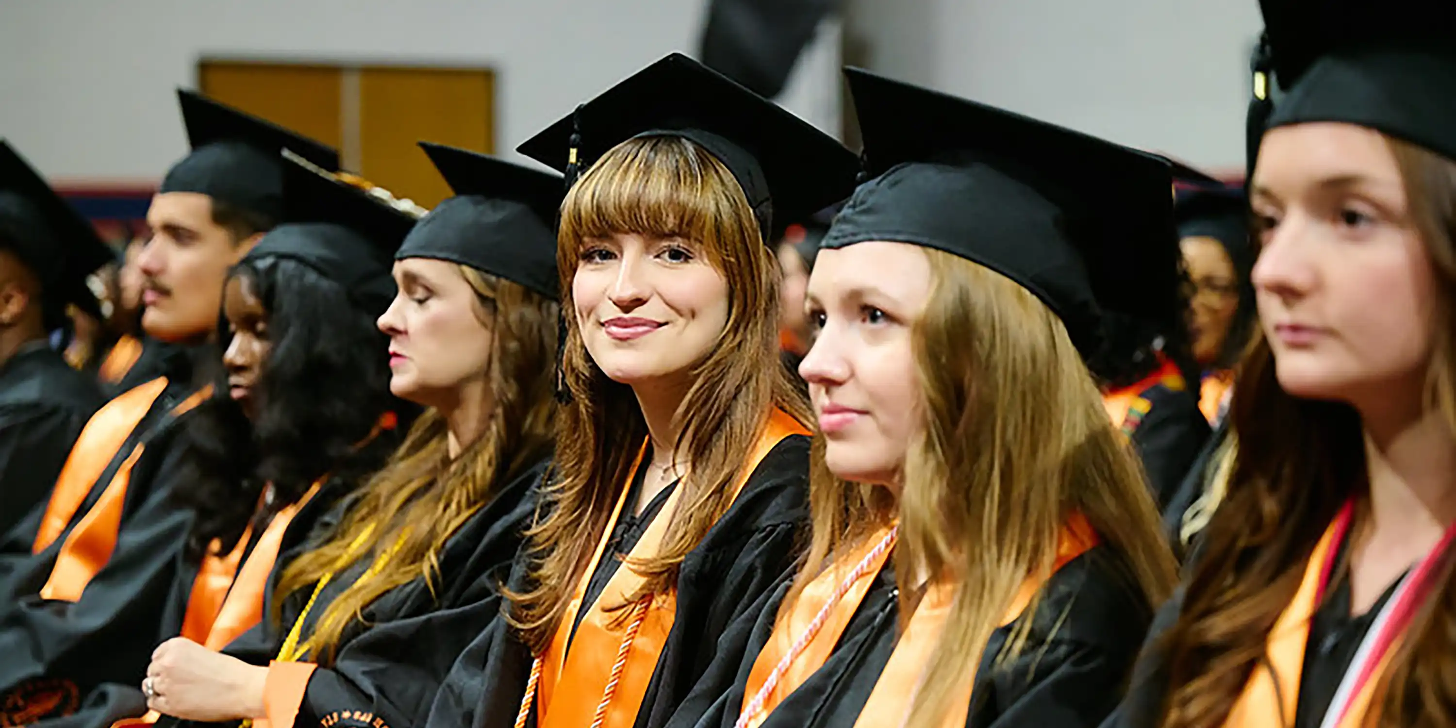 students in cap and gown at ceremony 