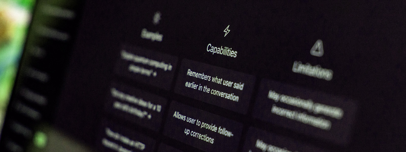 A close-up, slightly blurred shot of a computer monitor displaying the ChatGPT interface. The word "Capabilities" is centered above several text boxes, including "Remembers what user said earlier in the conversation" and "Trained to decline inappropriate requests."