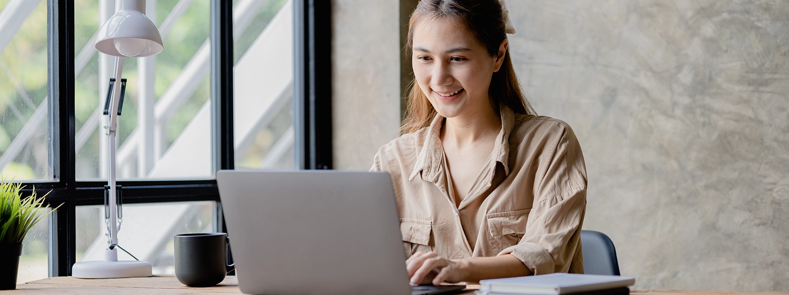 A female student in her 20s using a laptop to take her online course
