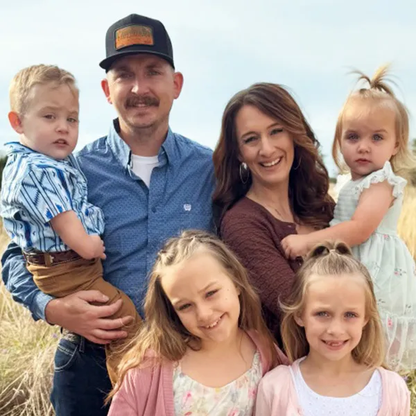 Mariah Howell Basinger, her husband, and four children in a picturesque field on easter Sunday