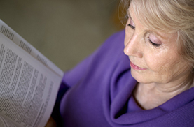 Woman reading textbook at home.