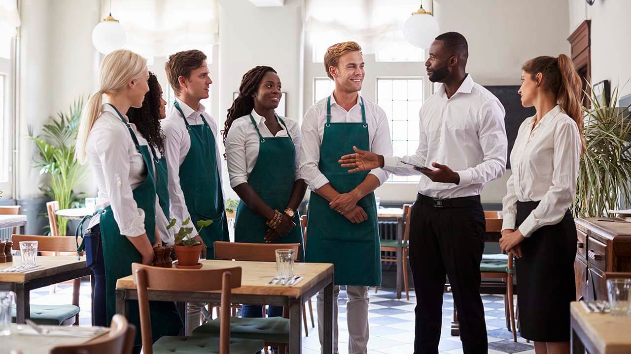 A team of servers and managers around a table.