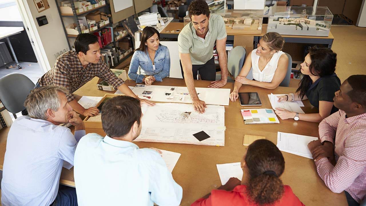 A team of designers around a table creating a mood board.