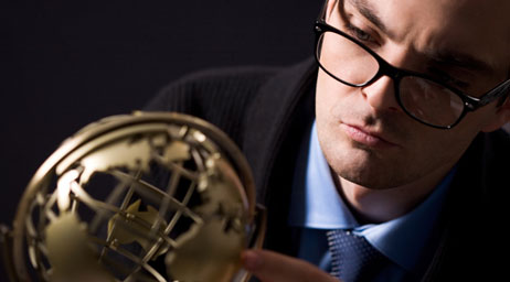 man looking at gold globe