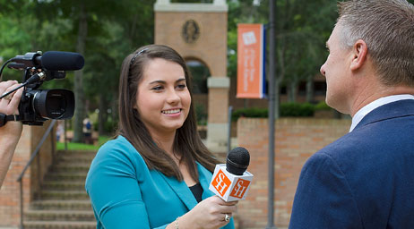 A woman is interviewing a man on camera at Sam Houston State University.