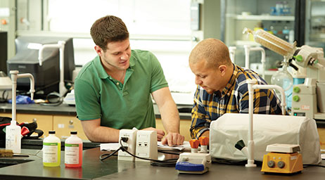 Two students are engaging in chemistry research in a laboratory.