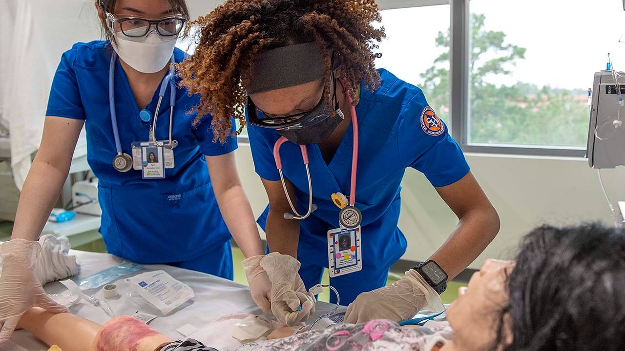 A nursing student practicing on a dummy.