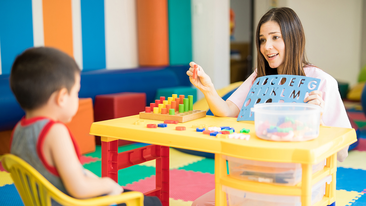 therapist working with a kid in a special needs school