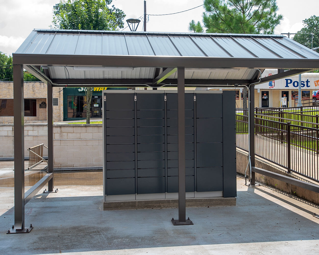 dark gray parcel lockers located under a canopy