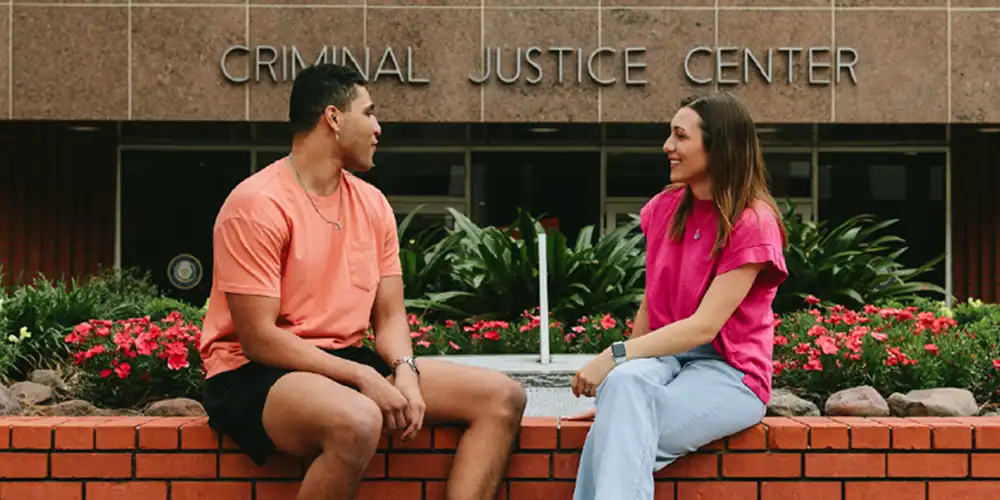 Two SHSU graduate students have a discussion outside of the George J. Beto Criminal Justice Center.