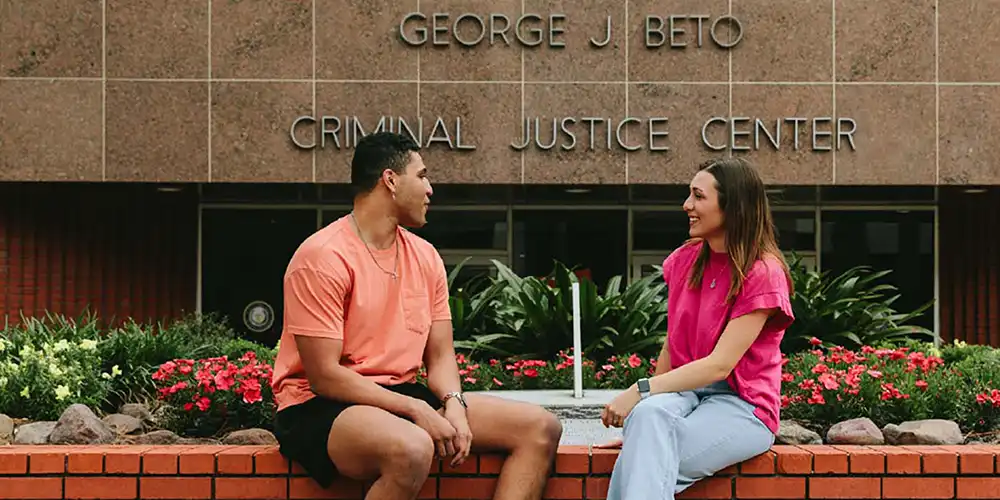 Two SHSU graduate students in conversation outside of the Beto Criminal Justice Center.