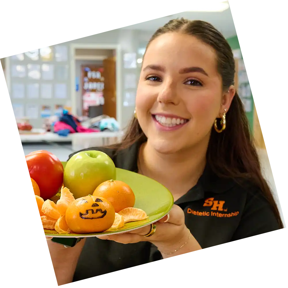 dietetics student holding a plate of fruits