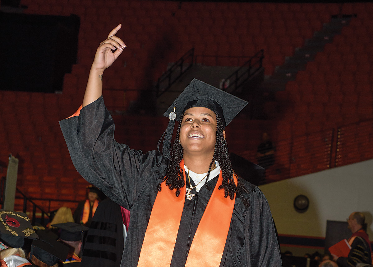 Student graduating, arm held high in celebration