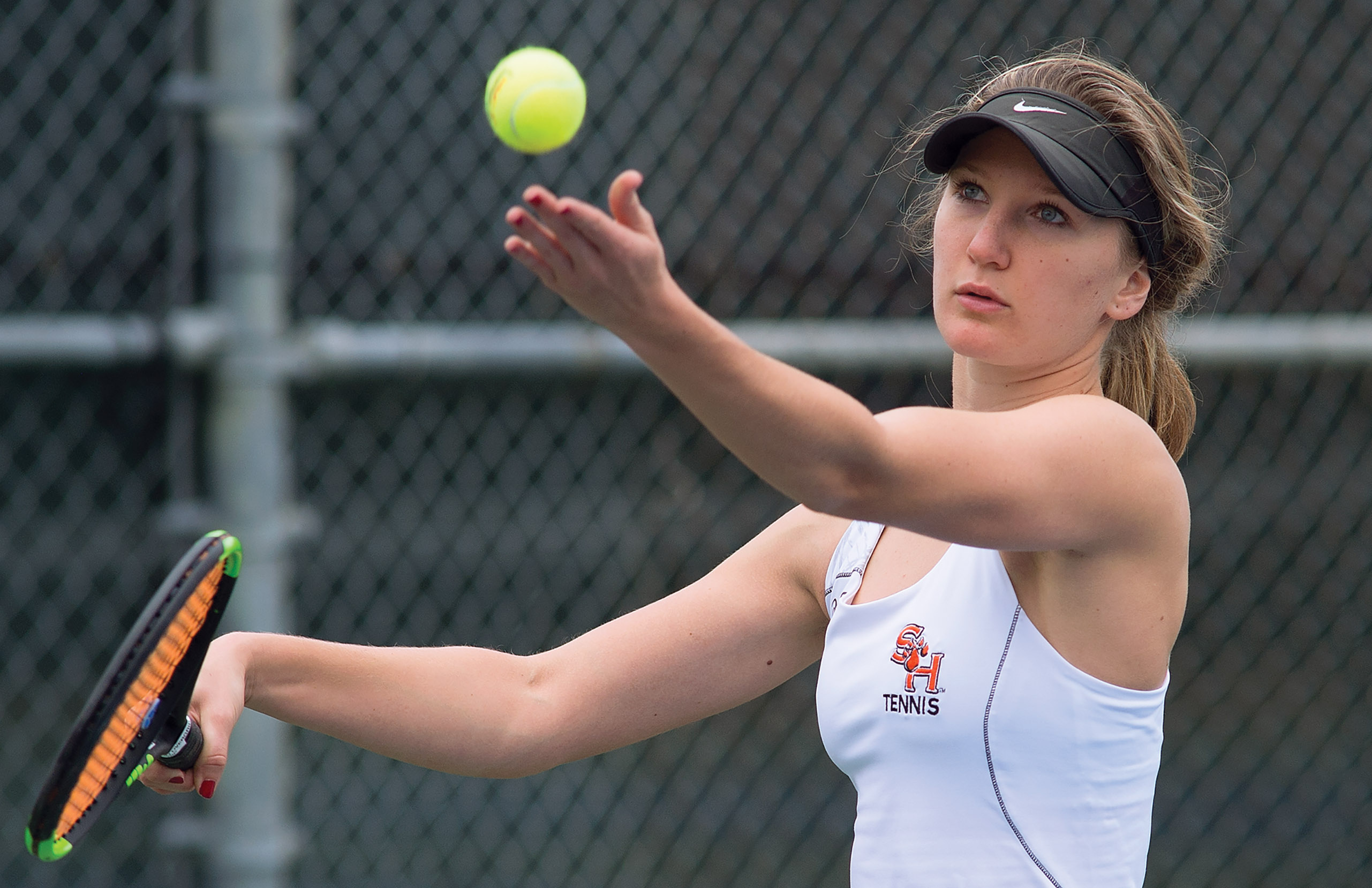 SHSU tennis player serving the tennis ball