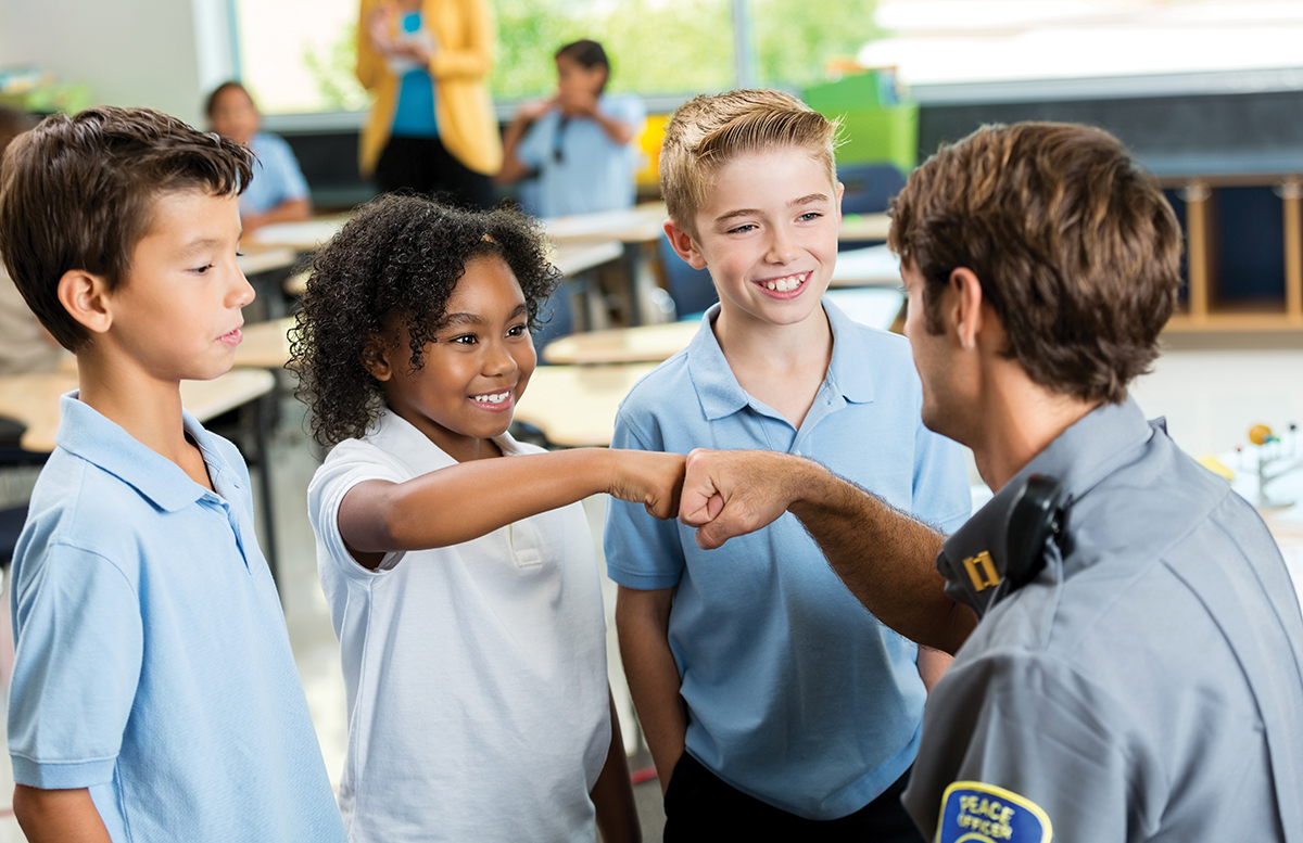 white police officer and Black child fist bump