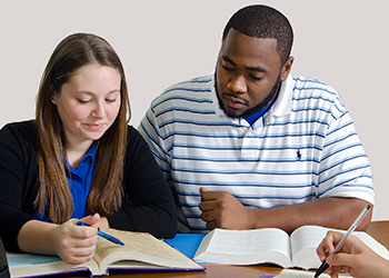 Two students collaborate on a paper.