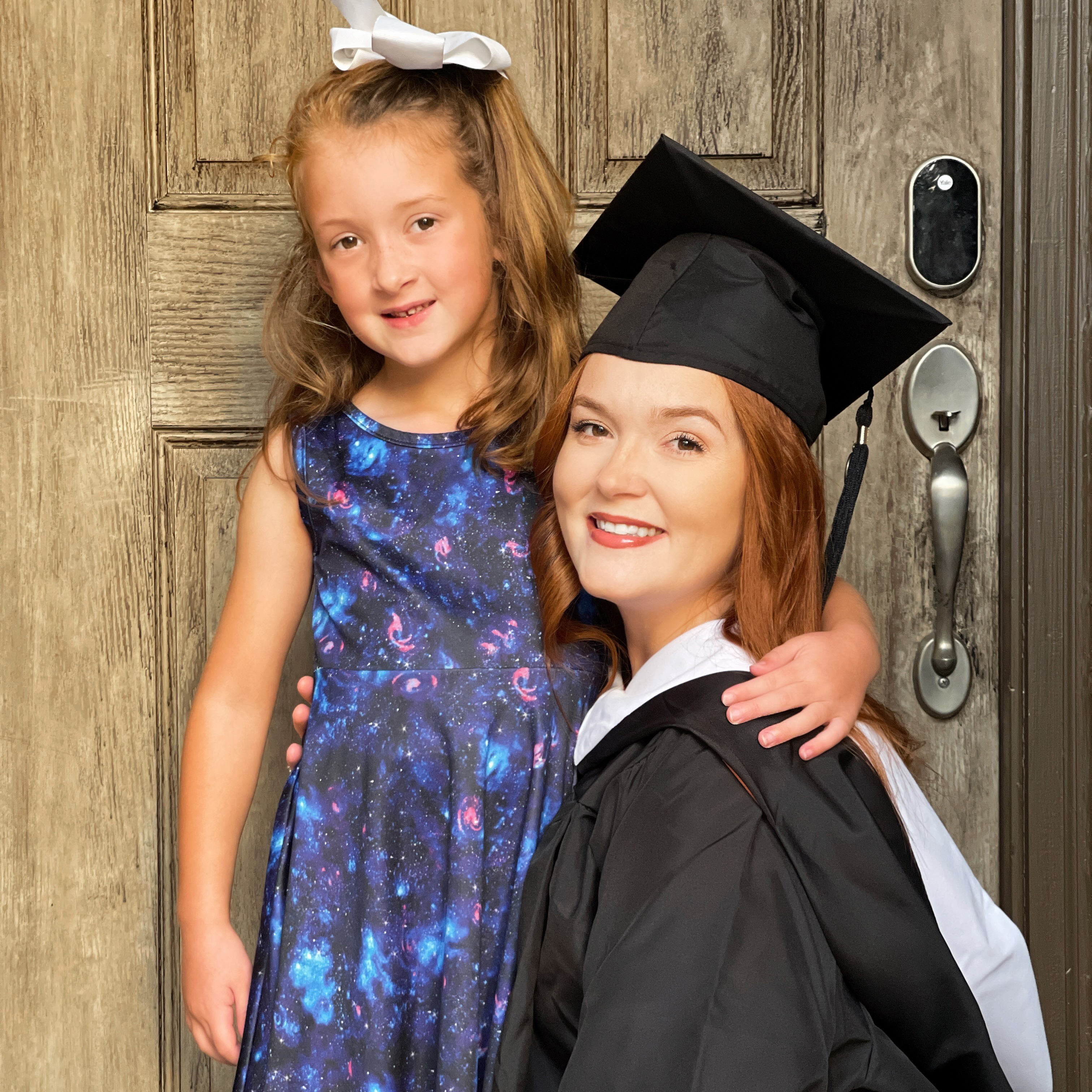 Anne posing with her daughter in her cap and gown..