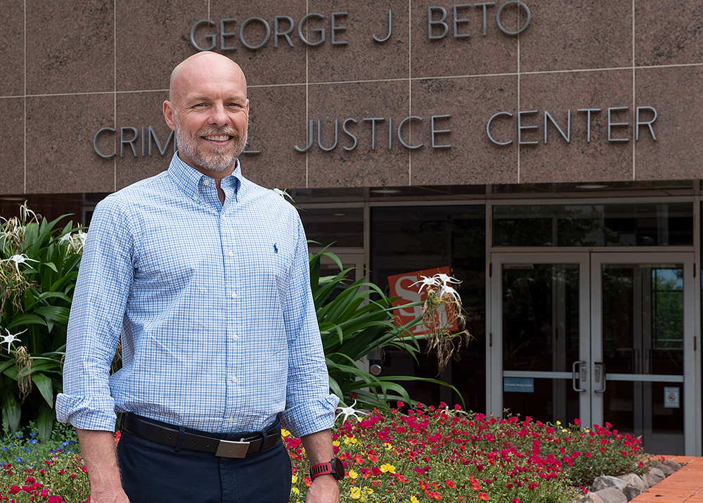 Bill Wells standing in front of the CJ building