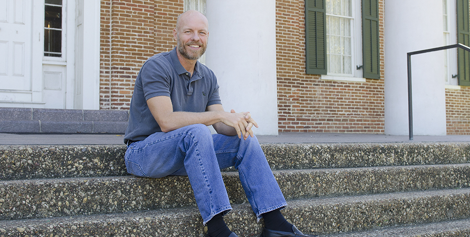 Bill Wells sitting in front of Austin Hall