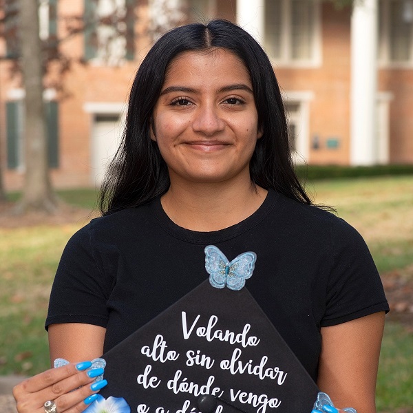 Jeannine Ramirez posing for with her customized mortarboard.