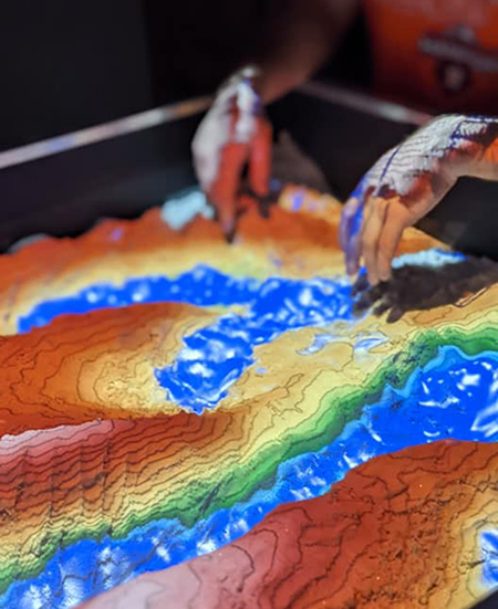 Student demonstrating how the sandbox topography works