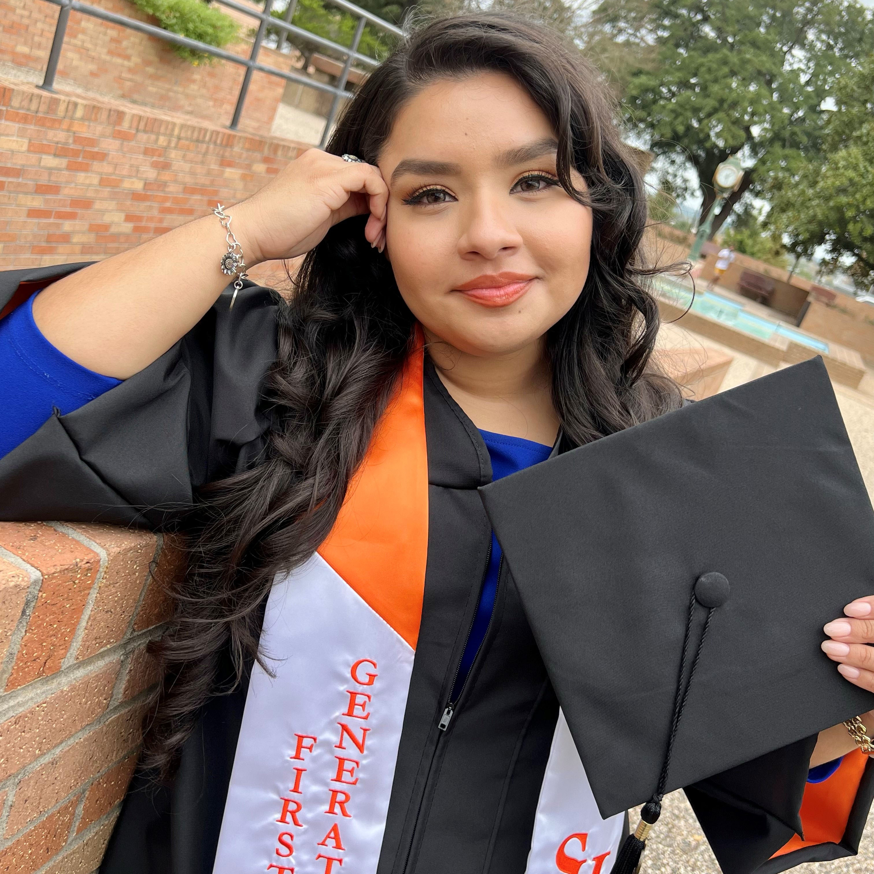 Vasty Nazario posing with cap and gown on the SHSU campus.