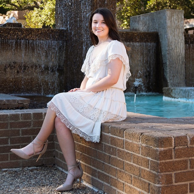 Emily McMillen sitting on the edge of the LSC fountain.