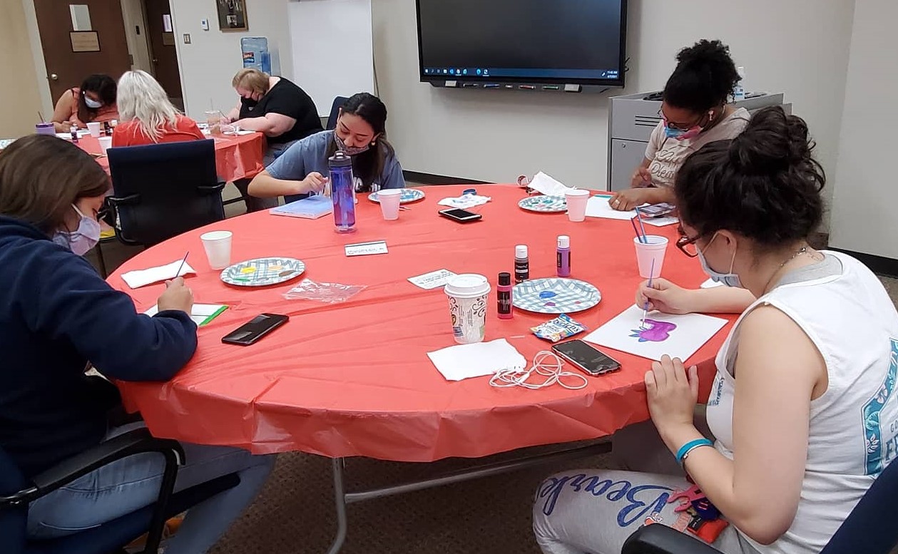 student painting around a table