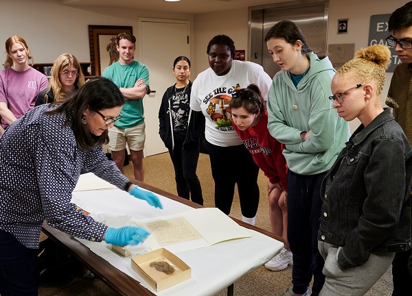 Rebecca Lewis shows students items from museum vault