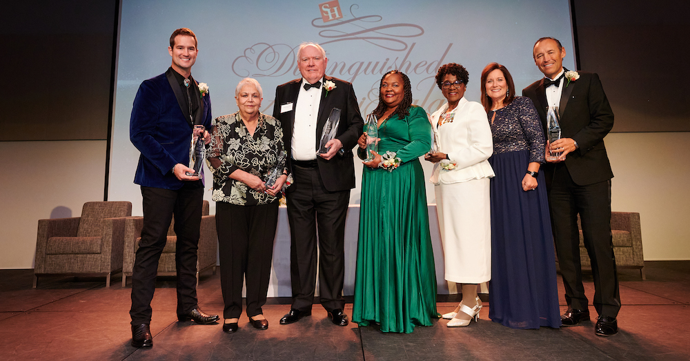 From left, Morgan Chesky, Rose Avalos, Paul Pearce, The Honorable Monica Thompson Guidry, Vanessa Hicks-Callaway and Beth and Kelly Damphousse take a photo after receiving their awards at the Distinguished Alumni Gala.