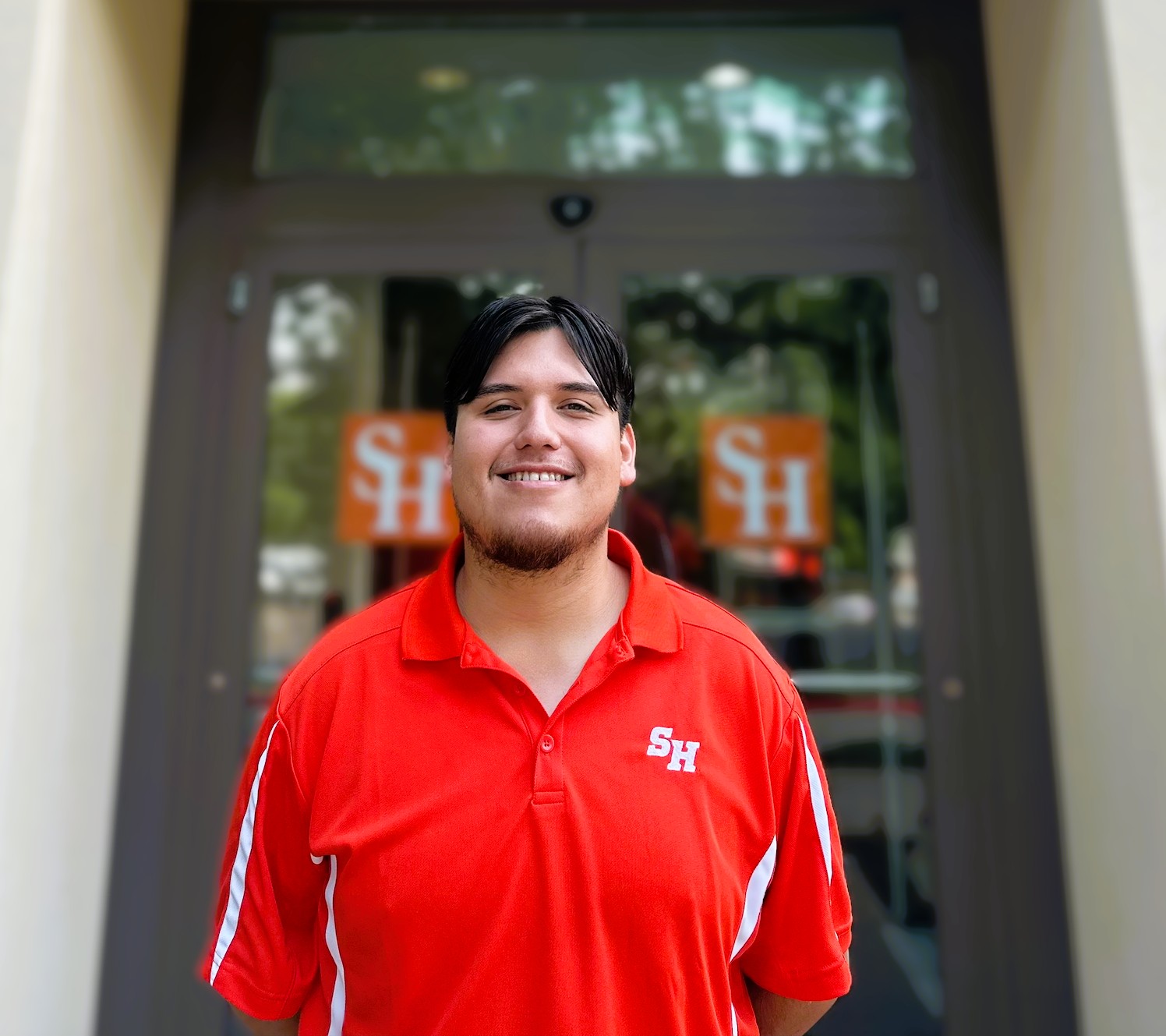 Photo of Caleb Ramirez in front of the Sam Houston State University Visitor Center. 