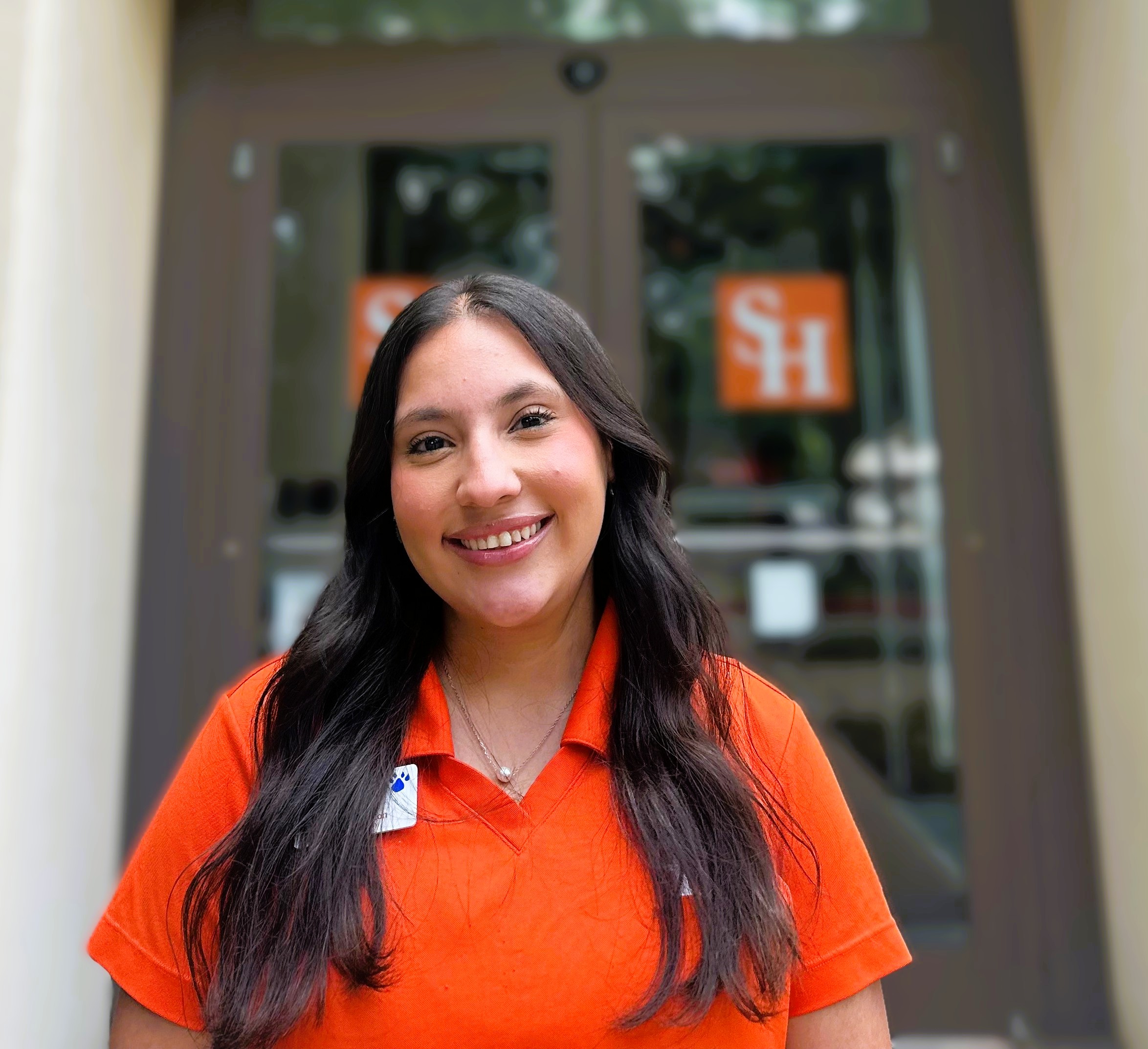 Photo of Mia Garcia in front of the Sam Houston State University Visitor Center. 